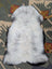 A soft fluffy gray and white large icelandic sheepskin rug with natural edges perfect for cozy decor angus oliver