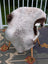 A plush light gray and brown icelandic sheepskin rug with long wool draped over a white chair by angus oliver