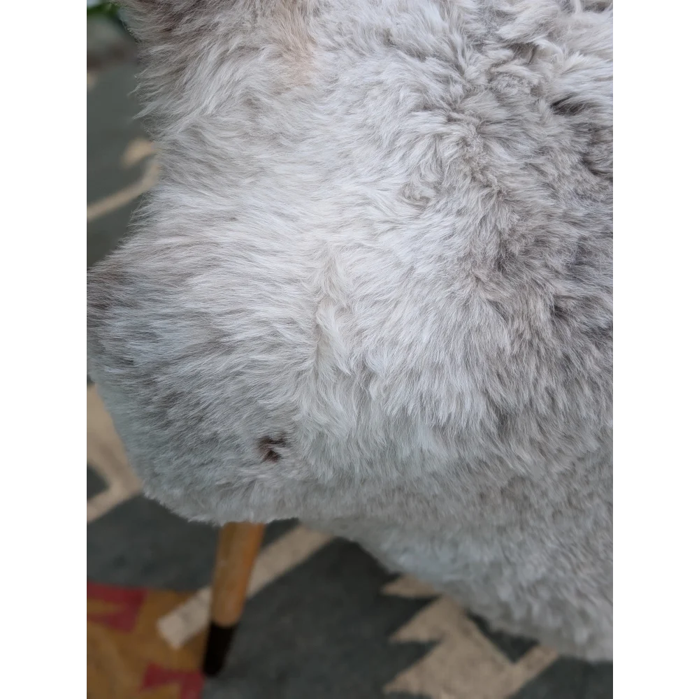 A plush gray fluffy icelandic sheepskin with long wool by angus oliver measuring 44 x 33 inches