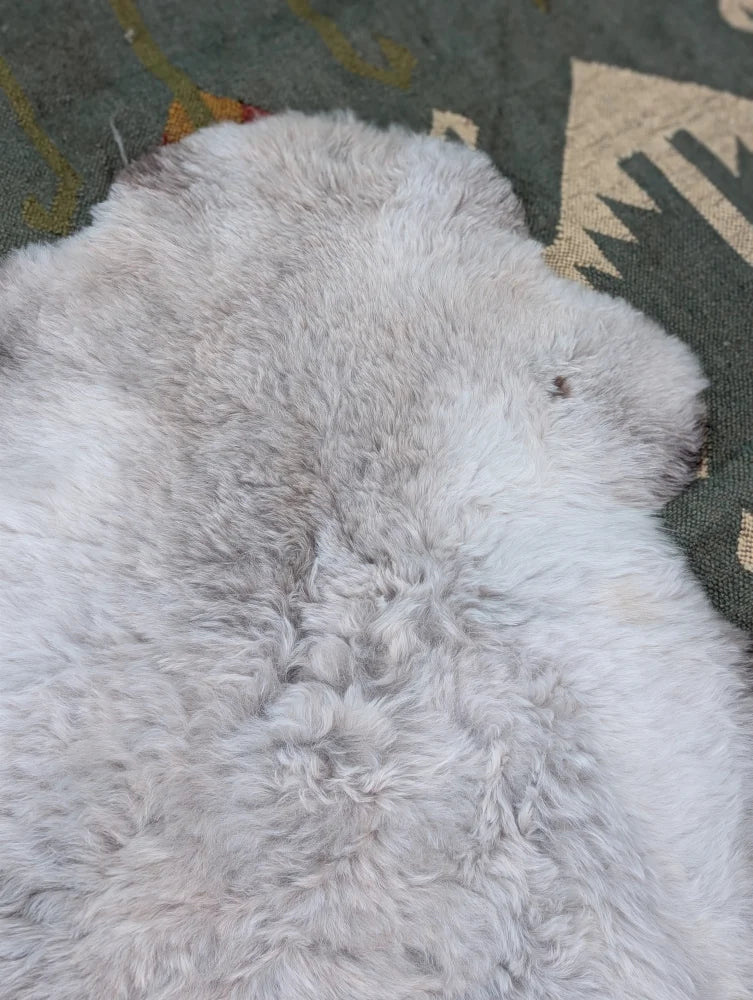 A large 44 x 33 inch soft long wool icelandic sheepskin rug with fluffy white and subtle grayish tones by angus oliver