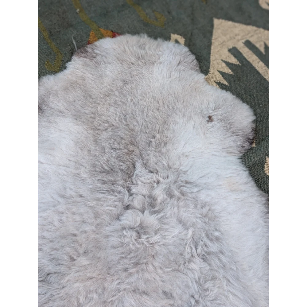 A large 44 x 33 inch soft long wool icelandic sheepskin rug with fluffy white and subtle grayish tones by angus oliver