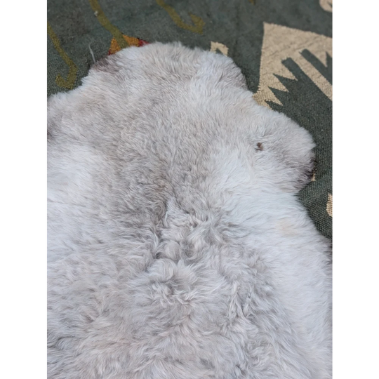 A large 44 x 33 inch soft long wool icelandic sheepskin rug with fluffy white and subtle grayish tones by angus oliver