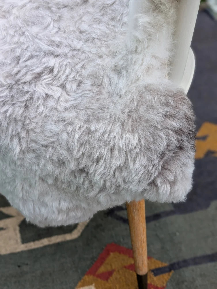A plush light gray angus oliver icelandic sheepskin chair cover with soft curly long wool icelandic texture