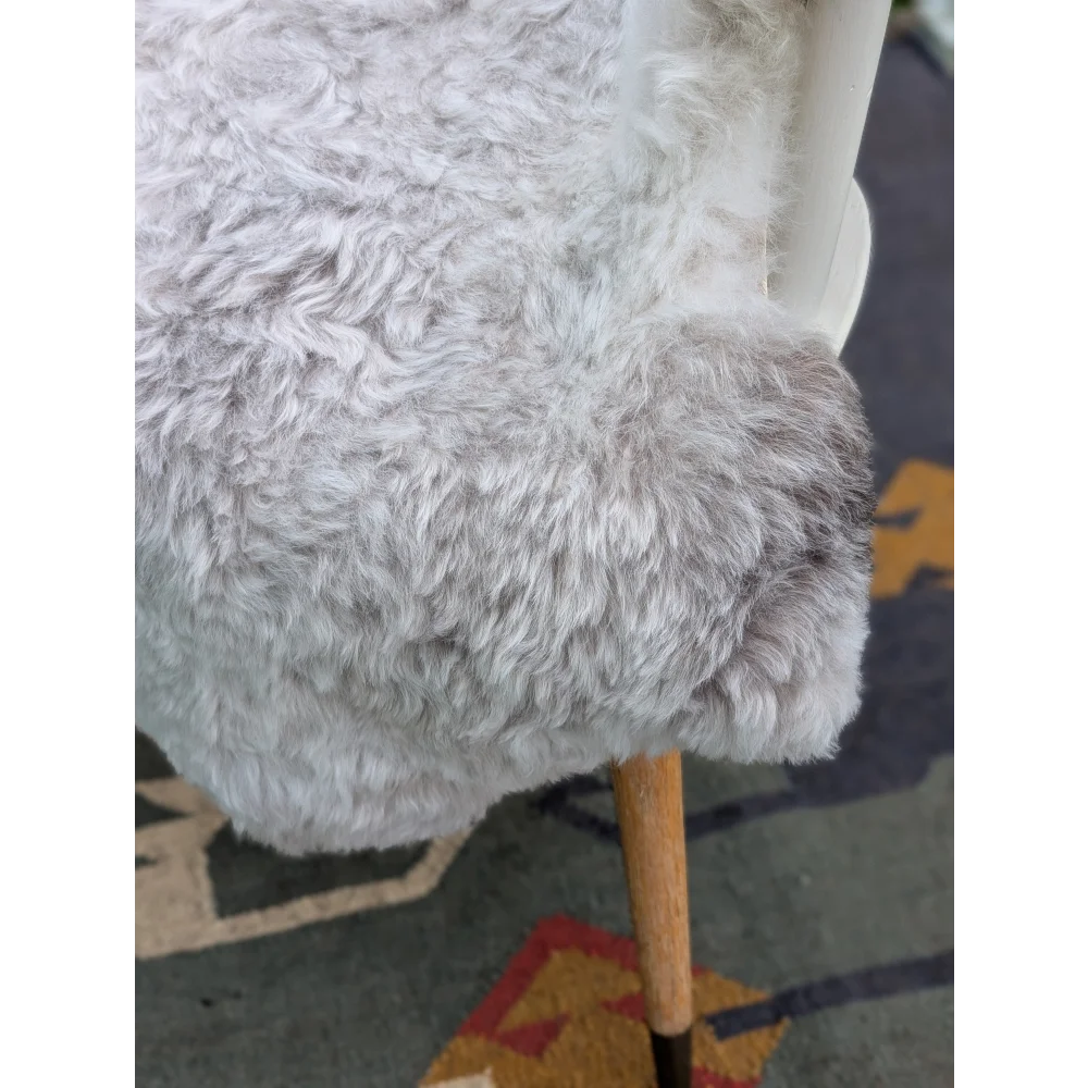 A plush light gray angus oliver icelandic sheepskin chair cover with soft curly long wool icelandic texture