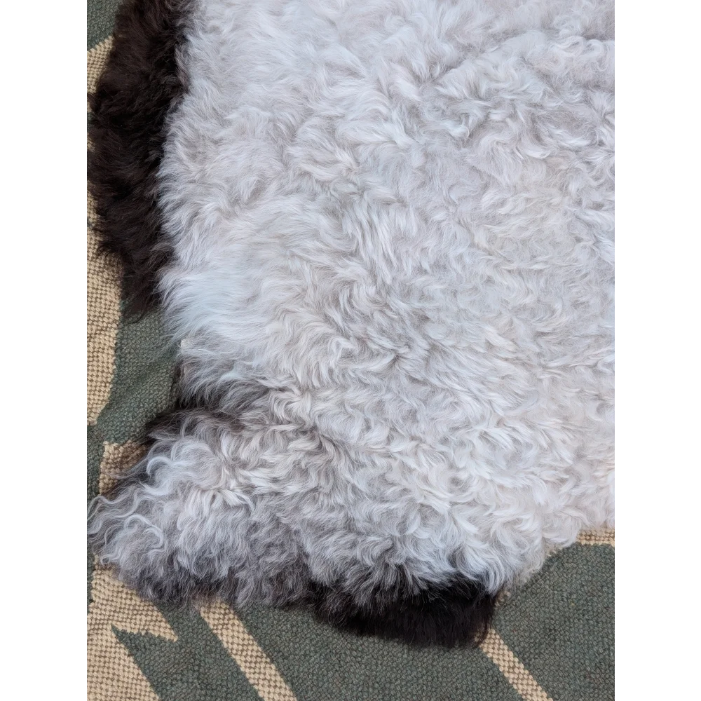 A plush large icelandic sheepskin rug with long wool in white and black by angus oliver measuring 43 x 35 inches