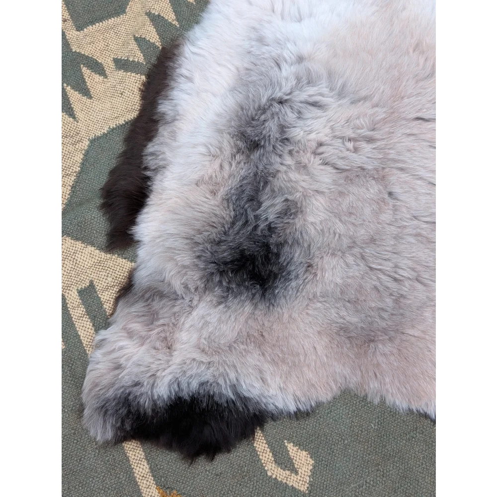 A large 43.5 x 33 inch gray and black long wool icelandic sheepskin rug with soft fluffy textured fur by angus oliver