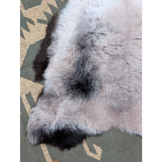A large 43.5 x 33 inch gray and black long wool icelandic sheepskin rug with soft fluffy textured fur by angus oliver