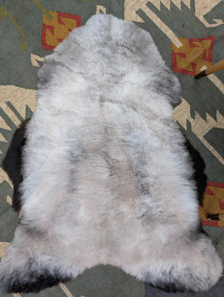 A soft fluffy gray icelandic sheepskin rug with long wool and natural irregular shape by angus oliver