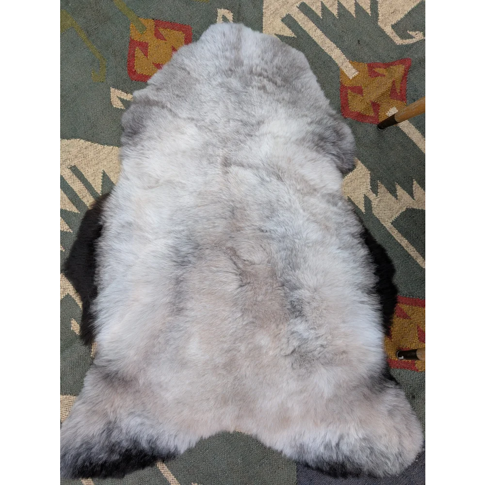 A soft fluffy gray icelandic sheepskin rug with long wool and natural irregular shape by angus oliver
