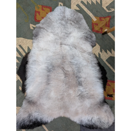 A soft fluffy gray icelandic sheepskin rug with long wool and natural irregular shape by angus oliver