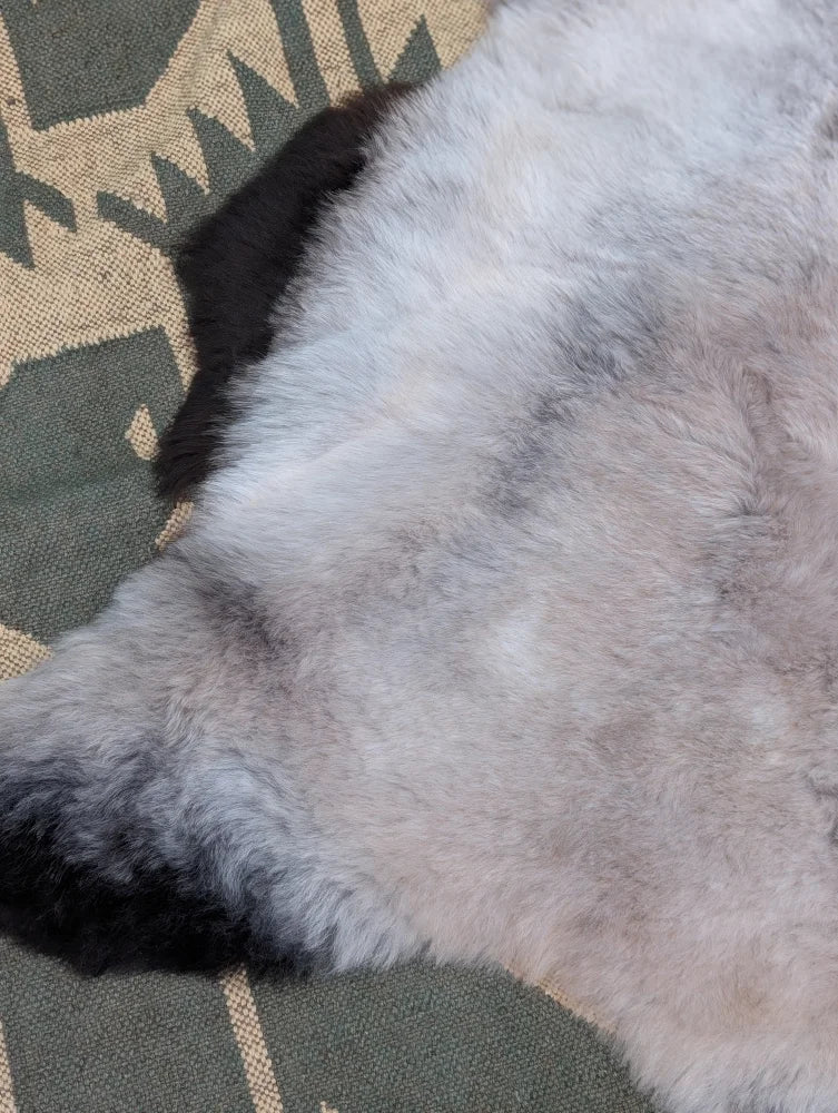 A large 44 x 31 inch icelandic sheepskin rug with soft long wool in gray and black by angus oliver