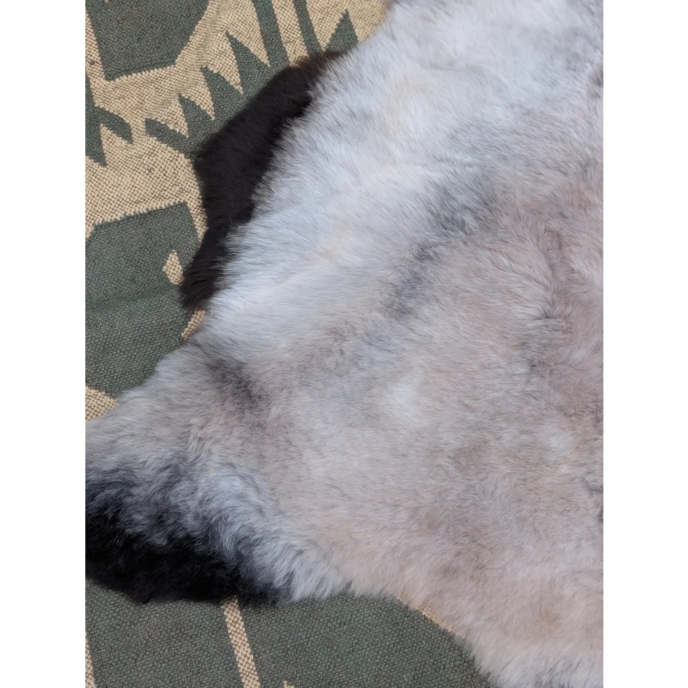 A large 44 x 31 inch icelandic sheepskin rug with soft long wool in gray and black by angus oliver
