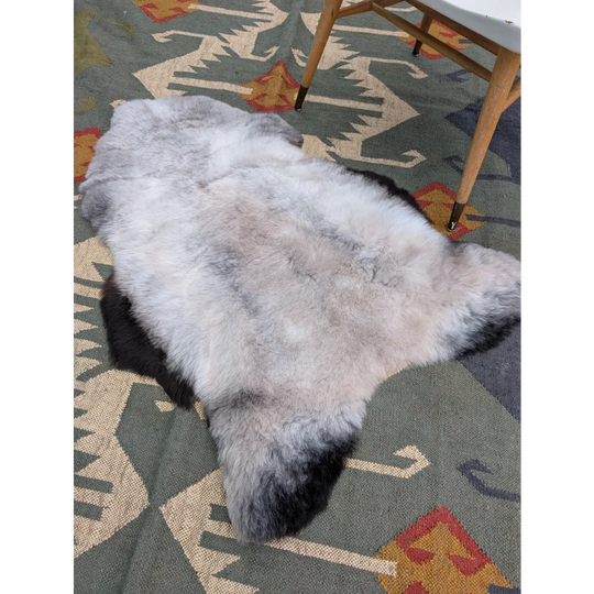A large 44 by 31 inch icelandic sheepskin rug with long wool gradient from gray to black by angus oliver