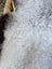 Large 43 x 31 inch icelandic sheepskin with soft long wool and dark edges featuring a curly gray patch and brown fur