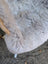 A plush light gray icelandic sheepskin cushion with soft long wool icelandic texture and natural dark edges