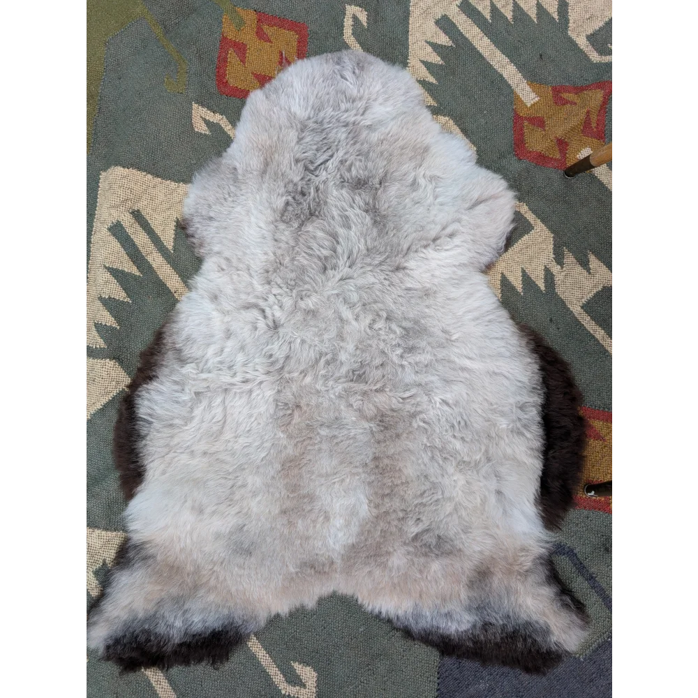 A soft fluffy gray and black long wool icelandic sheepskin rug with natural edges from angus oliver