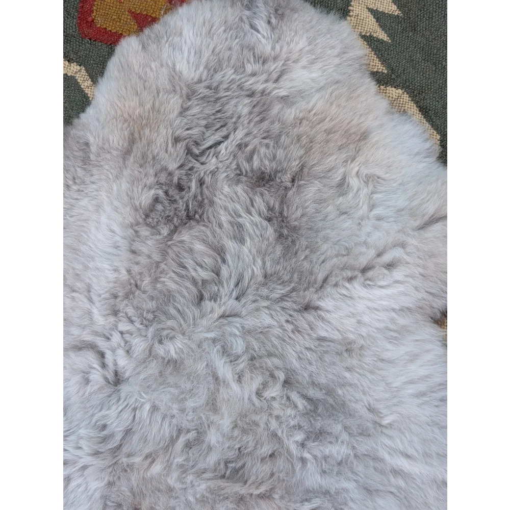 A soft light gray long wool icelandic sheepskin rug with natural fluffy texture by angus oliver measuring 43 x 31 inches