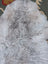 A soft light gray long wool icelandic sheepskin rug with natural fluffy texture by angus oliver measuring 43 x 31 inches
