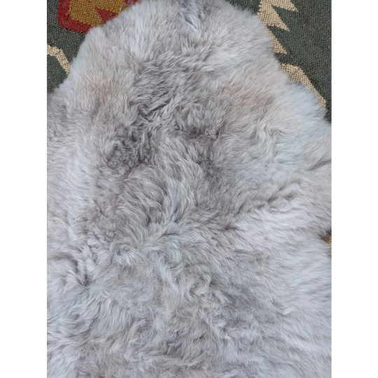 A soft light gray long wool icelandic sheepskin rug with natural fluffy texture by angus oliver measuring 43 x 31 inches