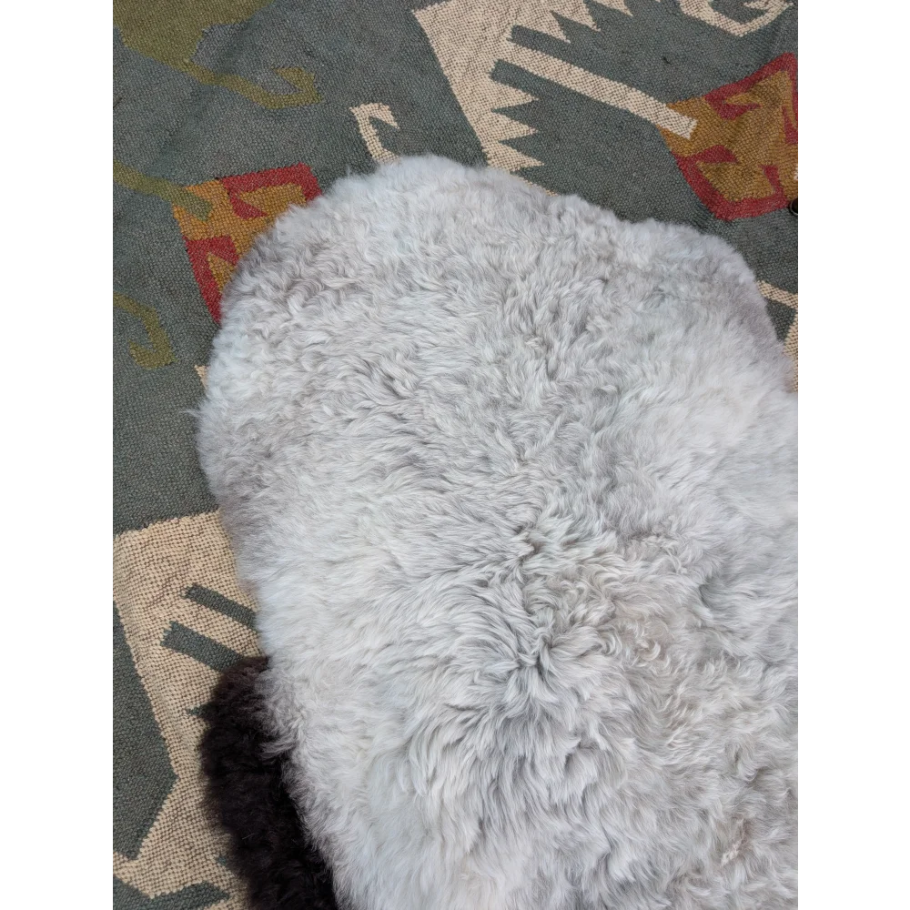 A soft light gray long wool icelandic sheepskin rug with plush curly texture by angus oliver measuring 44 x 33 inches