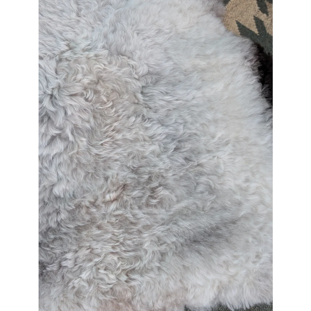 A soft curly white long wool icelandic sheepskin rug with natural fluffy texture by angus oliver measuring 44 x 33 inches