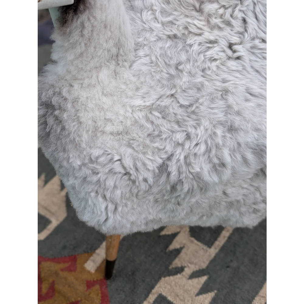 A plush light gray large icelandic sheepskin chair with long wool icelandic texture and wooden legs by Angus Oliver