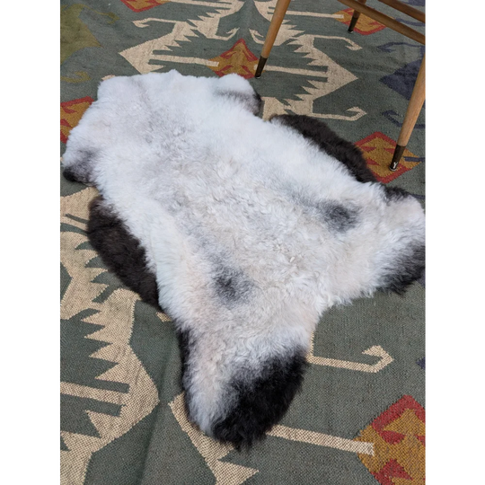 A large 43 by 31 inch icelandic sheepskin rug with soft white and black long wool by angus oliver
