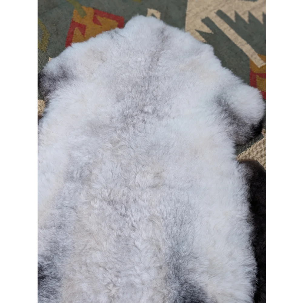 A large icelandic sheepskin rug in white and gray with long wool icelandic texture by angus oliver