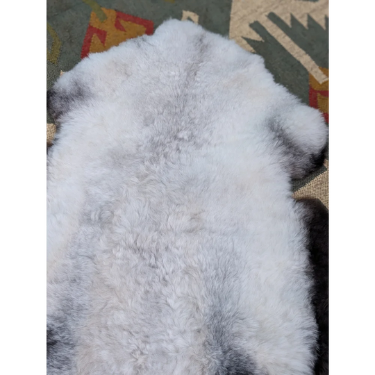 A large icelandic sheepskin rug in white and gray with long wool icelandic texture by angus oliver