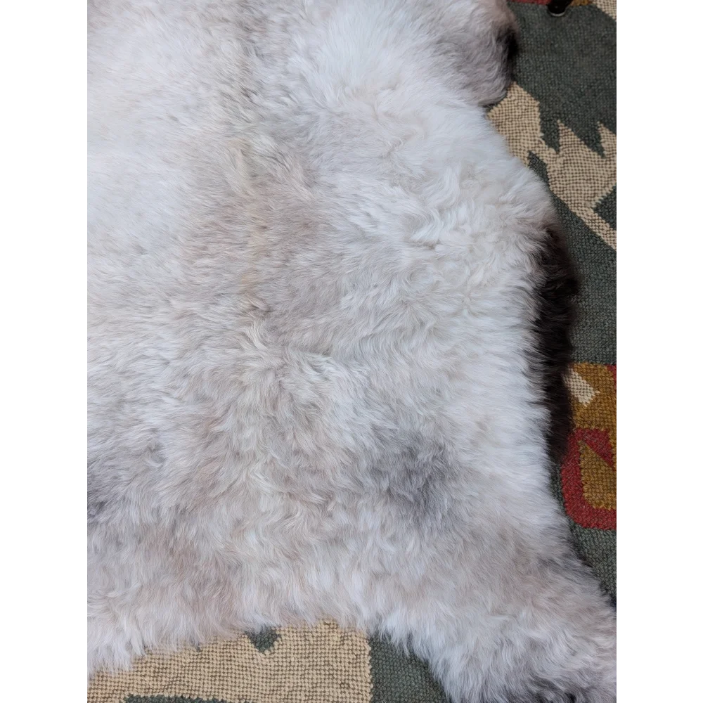 A plush white and light gray long wool icelandic sheepskin rug with a soft fluffy texture by angus oliver