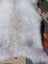 A plush white and light gray long wool icelandic sheepskin rug with a soft fluffy texture by angus oliver