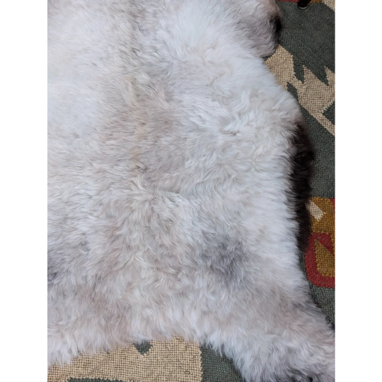 A plush white and light gray long wool icelandic sheepskin rug with a soft fluffy texture by angus oliver