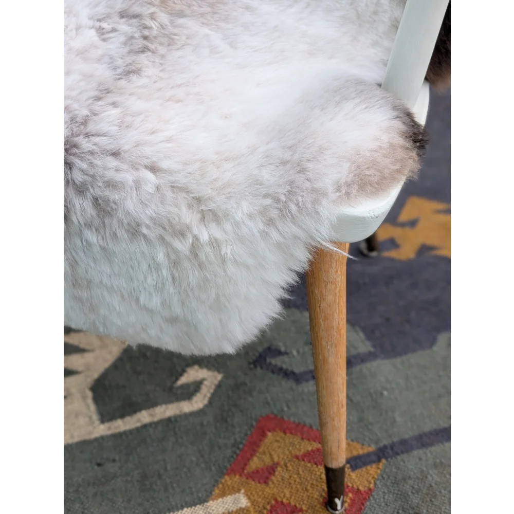 White fluffy fur chair cover with soft plush texture made of natural long wool icelandic sheepskin by angus oliver