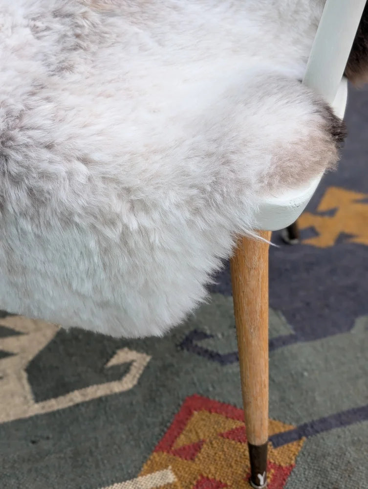 White fluffy fur chair cover with soft plush texture made of natural long wool icelandic sheepskin by angus oliver