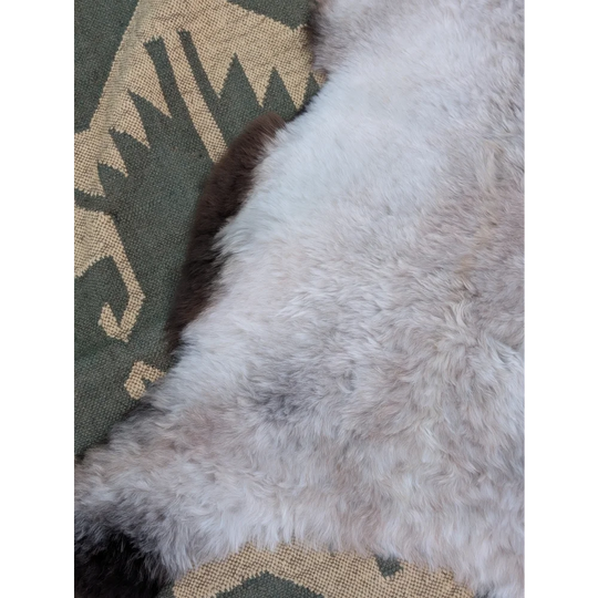 A large 44x27 inch icelandic sheepskin rug with long wool icelandic soft fluffy white fur and subtle gray patches by angus oliver