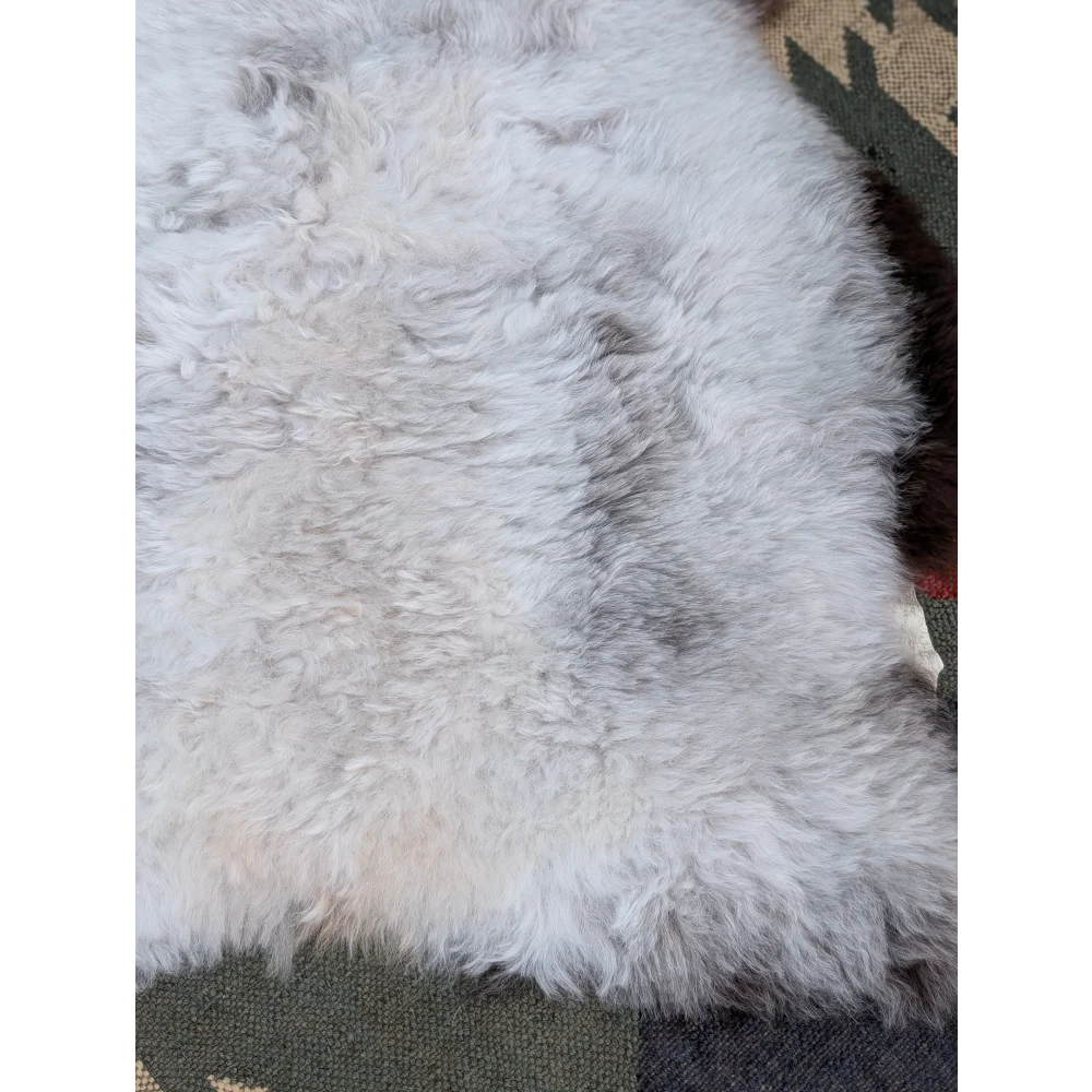 A large 44.5 x 31 inch soft fluffy icelandic sheepskin rug with long wool and natural gray beige undertones by angus oliver