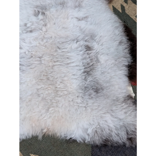 A large 44.5 x 31 inch soft fluffy icelandic sheepskin rug with long wool and natural gray beige undertones by angus oliver