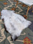 A soft fluffy white and gray large icelandic sheepskin rug with long wool and natural irregular edges by angus oliver