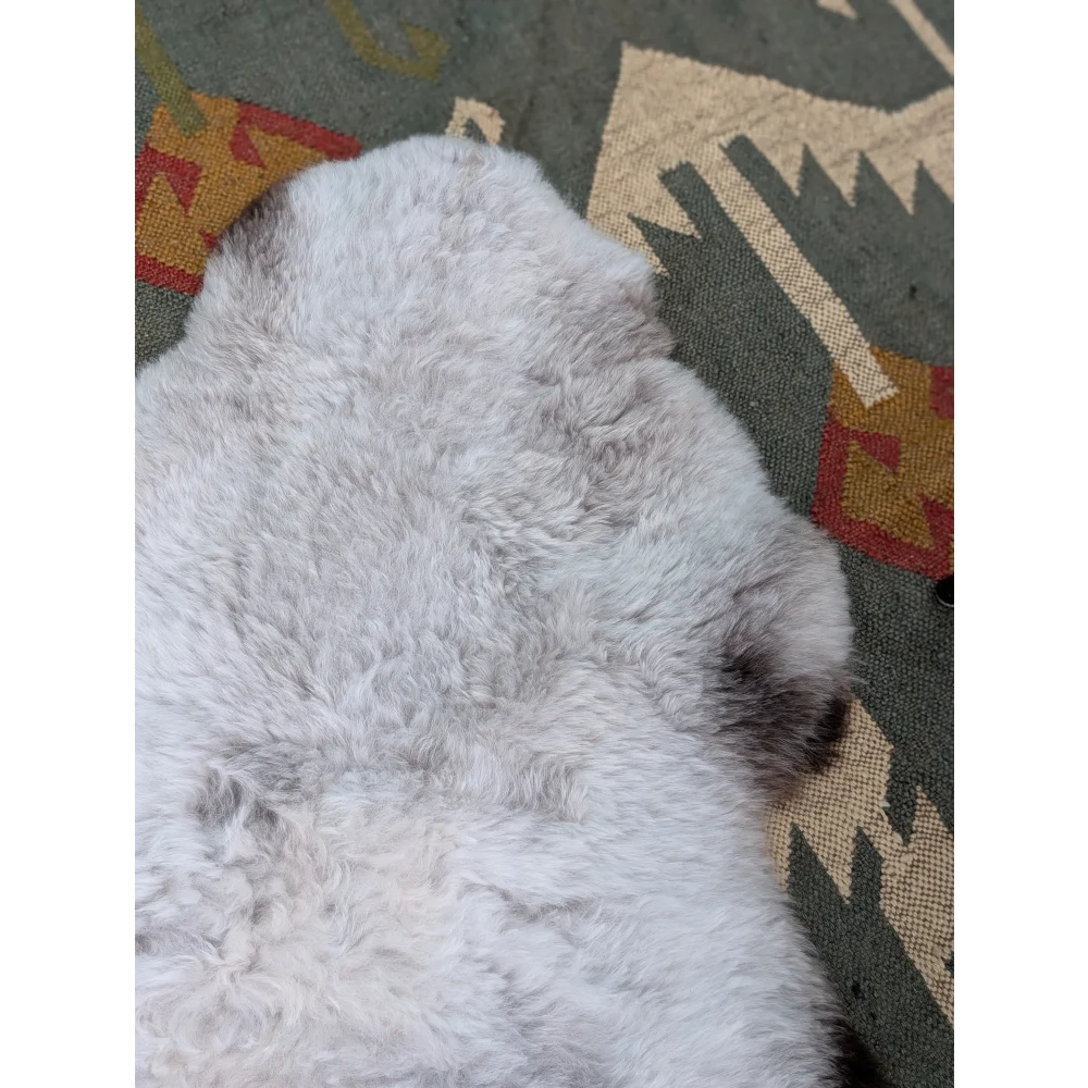 A soft fluffy gray long wool icelandic sheepskin rug 44.5 x 31 by angus oliver with natural texture and darker patches