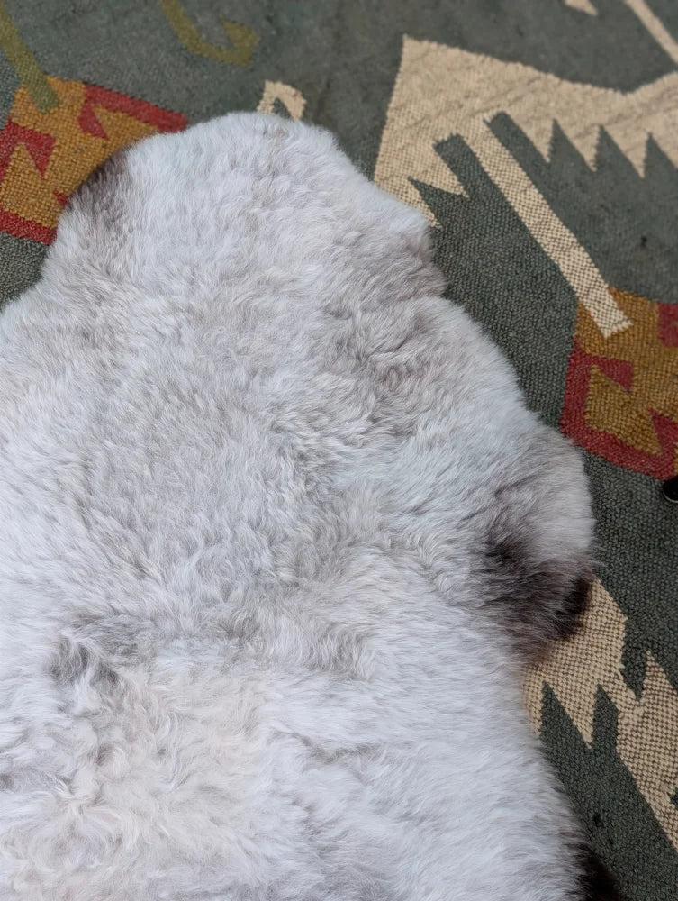 A soft fluffy gray long wool icelandic sheepskin rug 44.5 x 31 by angus oliver with natural texture and darker patches