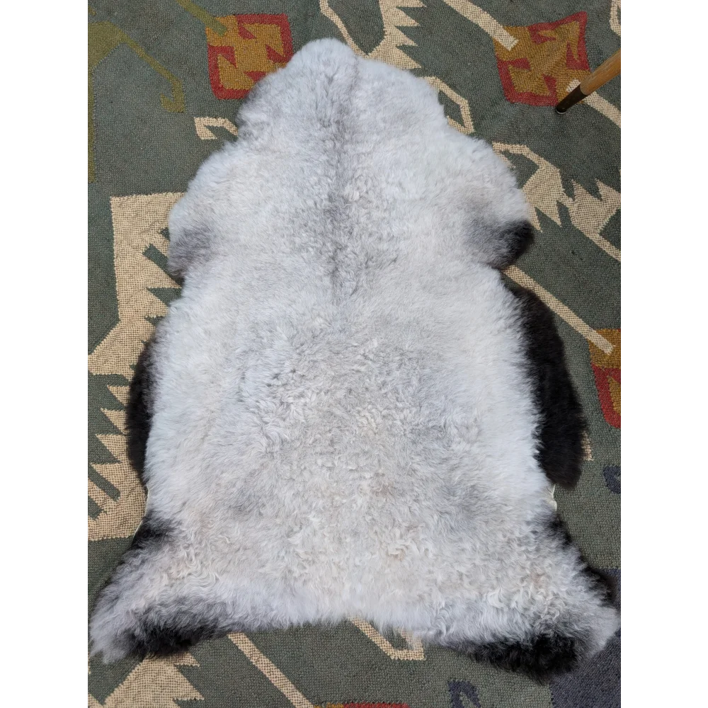 A soft curly white and black angus oliver icelandic sheepskin rug with long wool and fluffy natural texture