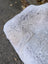 A soft light gray wool icelandic sheepskin cushion with plush texture and dark edges for cozy comfort