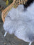 Large gray wool icelandic sheepskin chair pad with a soft natural texture and dark edges for cozy seating