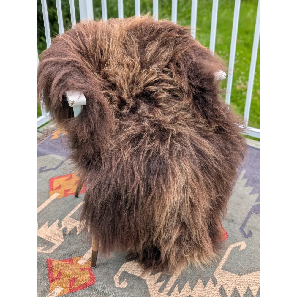 Thick shaggy brown icelandic sheepskin rug draped over chair showcasing long wool icelandic texture by angus oliver