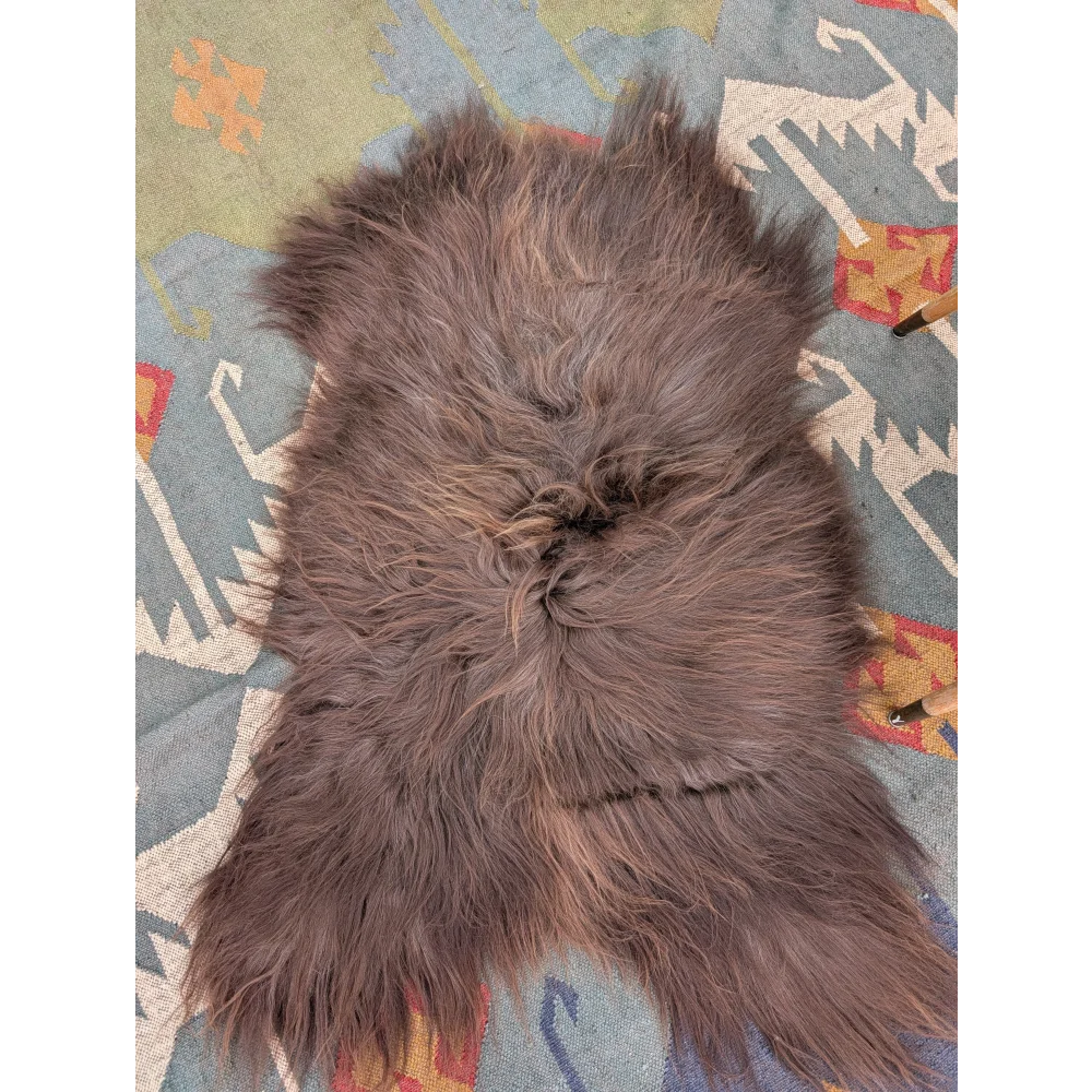 A plush 58 by 35 inch gray icelandic sheepskin rug with long wool and natural shade variations by angus oliver