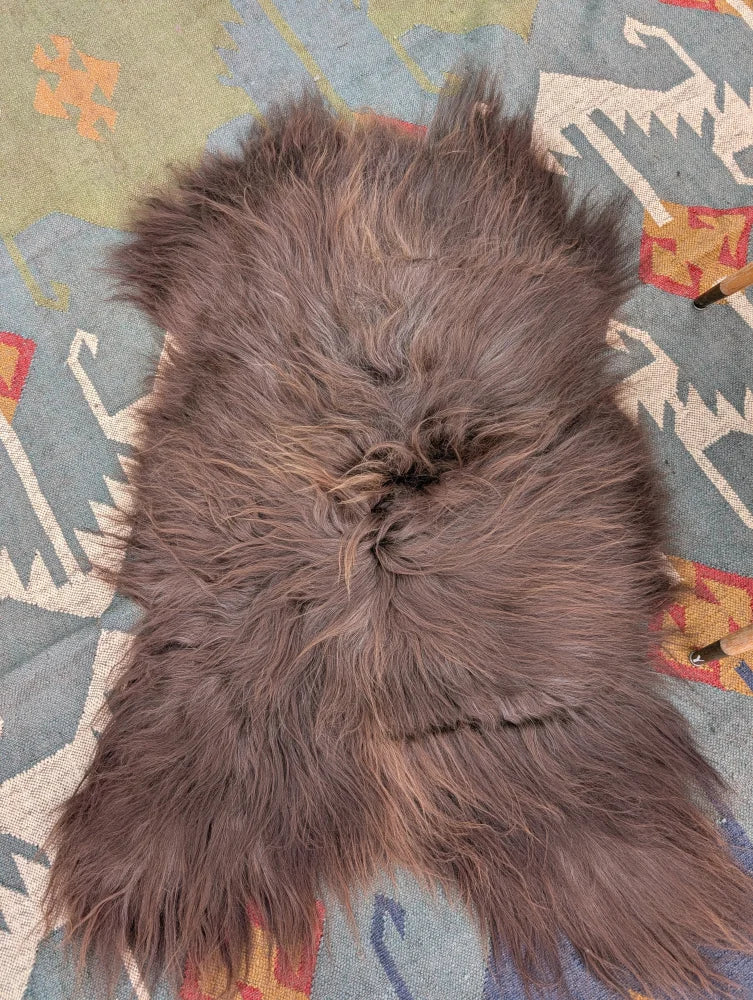 A plush 58 by 35 inch gray icelandic sheepskin rug with long wool and natural shade variations by angus oliver