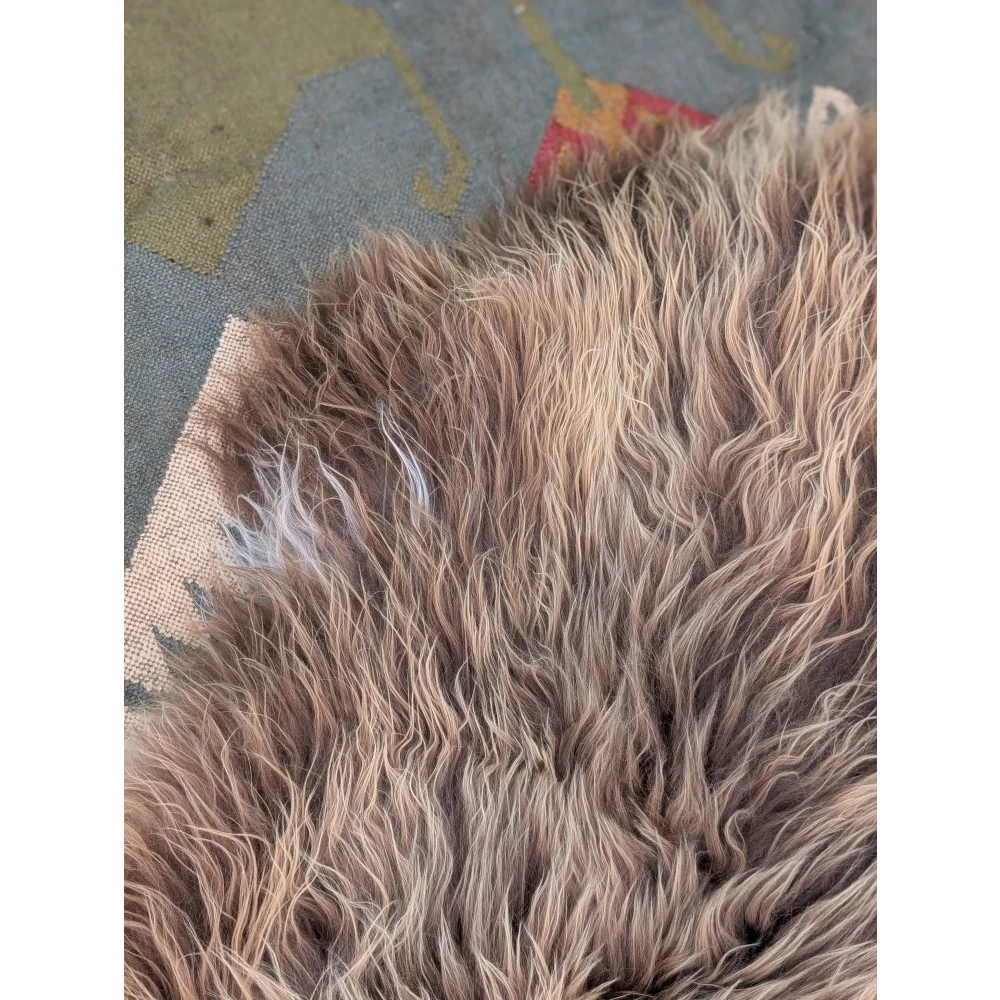 A plush long wool icelandic sheepskin rug in beige and brown tones by angus oliver measuring 59 x 34 inches