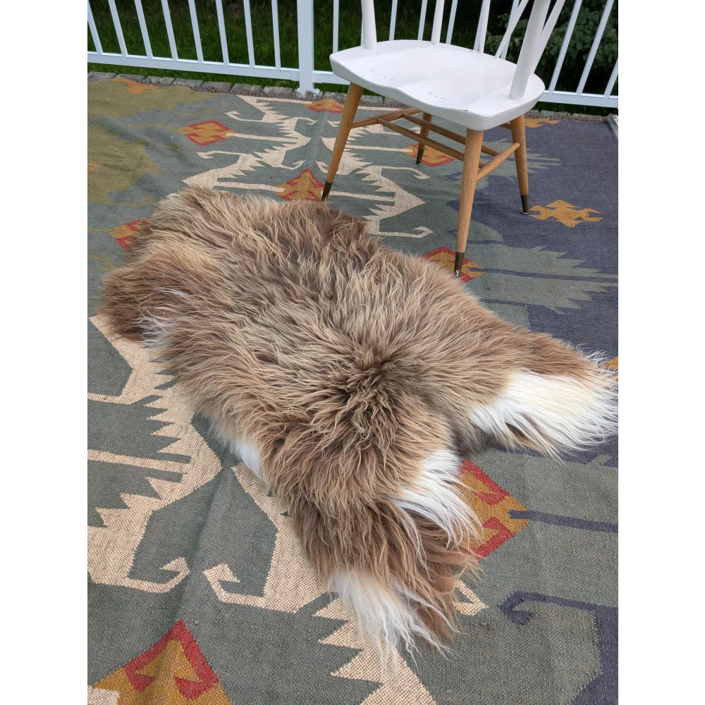 A fluffy natural-toned massive icelandic sheepskin rug with long wool in tan and white by angus oliver