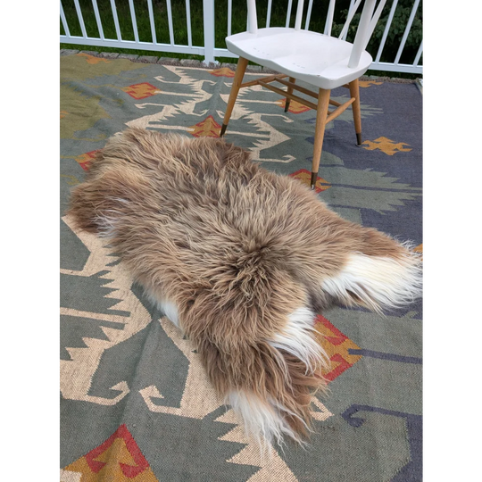 A fluffy natural-toned massive icelandic sheepskin rug with long wool in tan and white by angus oliver