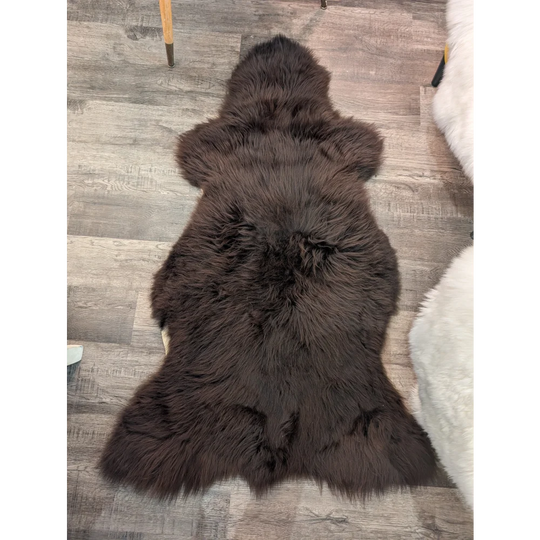 A plush extra large dark brown british sheepskin rug by angus oliver with natural fluffy texture and irregular edges
